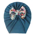 Detail of teal baby turban hat with a large colorful floral bow on white background - Navy Blue