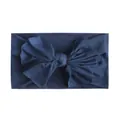 Close-up van een zachte marineblauwe nylon hoofdband met een grote strik voor baby's - Marineblauw