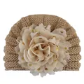 Nahaufnahme Baby-Strickmütze mit großer Goldpunkt-Chiffonblume als Detail - Kaffeebraun
