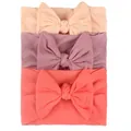 Detalle de tres diademas elásticas de nailon para bebé con lazos hechos a mano en tonos pastel - Rosa, Morado Taro, Pasta de Frijol