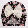 Dettaglio di turbante per neonata con fiocco bianco a pois dorati e fiori rosa - Nero + Bianco