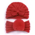 Detail of red cable-knit baby turban hat with bow and matching faux fur pom-pom headband - Red