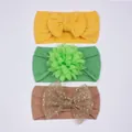 Détail de trois bandeaux pour bébés avec nœuds jaunes et fleurs en tissu vert tendre - Jaune Terre Vert Café