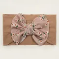 Detail of baby headband with tan elastic base and purple floral daisy bow ornament - Coffee