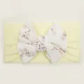 Detail of baby headband featuring yellow ribbed bow with delicate floral print - Beige