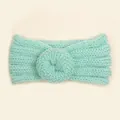 Close-up of mint green knitted baby headband with donut design and soft ribbed texture - Mint Green
