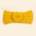 Vue macro du bandeau tricoté jaune gingembre avec détail de nœud donut et texture côtelée - Jaune
