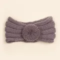 Gros plan d'un bandeau en maille lilas pour bébé avec texture fleur de donut douce - Gris