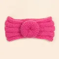 Détail d'un bandeau en maille rose pour bébé avec motif donut 3D et texture côtelée - Rose rouge