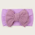 Detail of purple baby headband featuring a soft waffle texture oversized double bow - Purple