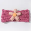 Detail of baby knitted headband featuring a pink checkered flower and knit texture - Rose Red