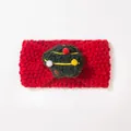 Detailaufnahme eines roten Strick-Baby-Stirnbands mit festlichem grünen Bommel-Weihnachtsbaum - Rot Weihnachtsbaum-Ball Stil