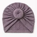 Close-up of deep purple knit baby donut turban hat with intricate cable stitch texture - Taro Purple