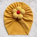 Détail d'un bonnet turban jaune pour bébé avec texture gaufrée et grande fleur en 3D - Jaune