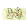 Détail d'un bandeau bébé avec un grand nœud jaune à motif marguerites sur tissu élastique - Beige