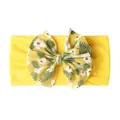 Détail du bandeau bébé en maille jaune avec motif floral tropical sur le nœud - Jaune Vif