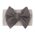 Detailed shot of baby nylon headband featuring textured charcoal bow and soft elastic band - Gray