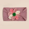 Dettaglio fascia per neonati in nylon con fiore in tessuto e bottone verde centrale - viola taro