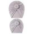 Detail of grey parent-child donut hats featuring soft knitted cotton and top knot design - Gray