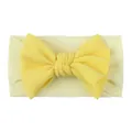 Detail of yellow bow baby headband showing ribbed fabric texture and elastic nylon material - Beige