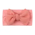 Close-up of soft pink baby headband with large waffle knit bow and wide elastic band - Pink