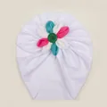 Detailed macro view of white ribbed knit fabric and colorful flower on the baby turban hat - White