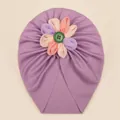 Détail du bonnet turban violet pour bébé avec fleur en tissu colorée et bouton vert - Violet