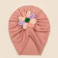 Détail d'un bonnet turban rose côtelé pour bébé avec fleur en tissu colorée et bouton vert - Rose chair