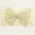 Detail of cream baby headband featuring a soft nylon mesh bow with silver glitter polka dots - Beige