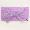 Detailed shot of purple nylon baby headband featuring a sparkling silver sequin mesh bow - Purple