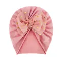 Detailierte Textur der rosa Baby-Turban-Mütze mit großer goldener Polka-Dot-Schleife - Altrosa