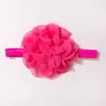 Dettaglio macro di un fiore in chiffon rosa su fascia elastica per neonati - Rosso rosa