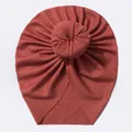 Détail du bonnet turban bébé rouge rouille avec nœud donut et texture maille côtelée - Bordeaux