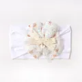 Close-up of white baby headband featuring lace floral patterns and a crochet bow detail - White