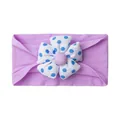 Detail of soft lavender elastic baby headband featuring a large blue polka dot floral motif - Purple