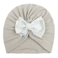 Detail van baby tulband muts met kantstrik, parels en zachte grijze gebreide stof - Grijs