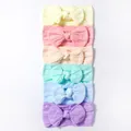 Dettaglio del set di 6 fasce per neonati in nylon con trama a maglia e fiocco color pastello - Combinazione Giallo Rosa Nudo Menta Blu E Viola