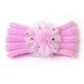 Detailansicht eines rosa gestrickten Baby Stirnbands mit großer Spitzenblume und Pailletten - Rosa