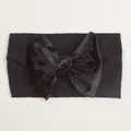 Gros plan d'un grand nœud en velours noir sur un bandeau élastique en nylon pour bébé - Noir