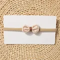 Detail of baby bow headband with beige fabric and brown stitching on woven mat - Beige Bow With Brown Ribbon