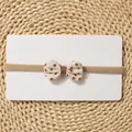 Detail of baby elastic headband with floral bow on display card with straw mat background - Beige Floral Bow