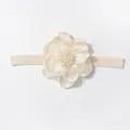 Dettaglio di fascia per neonati con fiore in organza a strati e perle su nastro elastico - Beige