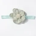 Detail van mintgroene baby haarband met gelaagde organza bloem en witte parelversiering - Groen