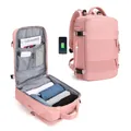 Pink travel backpack showing USB charging port and interior storage compartments - Pink