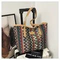 Detail einer gestrickten Bohème-Tasche mit Zickzack-Muster an einem weißen Koffer - Khaki