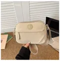 Dettaglio della borsa a tracolla in nylon beige con tasche a zip e tracolla in tessuto - Cachi