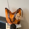 Gros plan du cabas en daim caramel avec breloque chien en peluche et bandoulière - Avec Pendentif / Marron