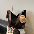 Détail du sac cabas en daim noir avec coins en cuir marron et breloque chien en peluche - Avec Pendentif / Noir