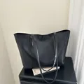 Bolso tote negro minimalista con correas largas en un pedestal de alto brillo - Negro