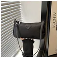 Minimalist black nylon underarm dumpling bag with silver triangular metal plaque detail - Black
